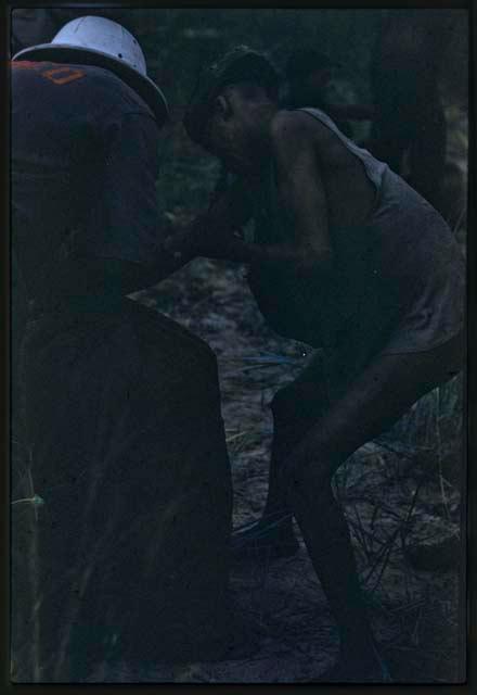 Woman having her arm examined or treated by Kernel Ledimo