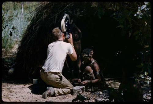 John Marshall filming !U and children in front of a shaded skerm