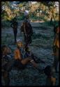 Group of young people gathered in the shade to watch something