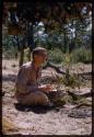 Nicholas England sitting and playing a //guashi