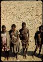 Group of people standing, including two missionary-trained women wearing dresses