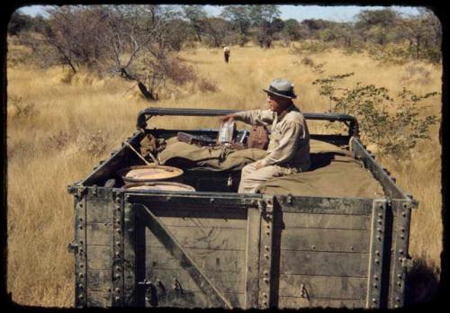 Laurence Marshall sitting on top of the expedition Dodge truck, referred to as "Hardship No. 57"