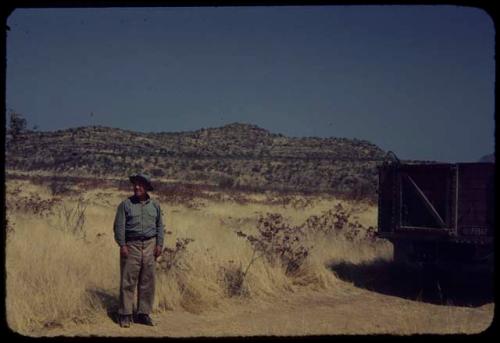 Laurence Marshall standing on a road beside the expedition truck