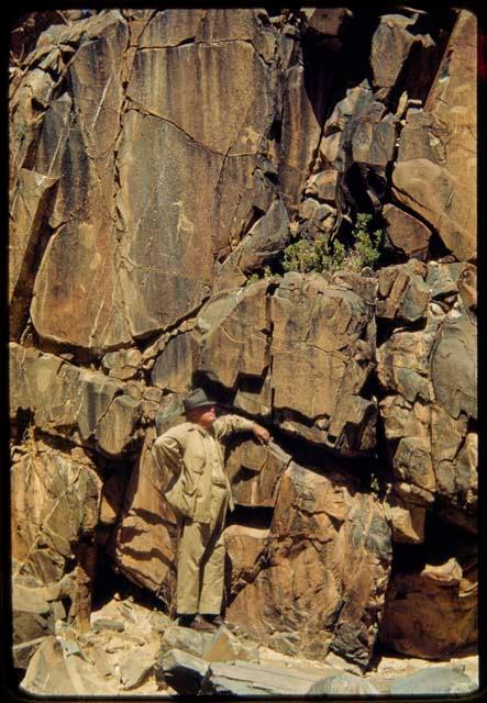 Merl La Voy next to a petroglyph at Scho-Scho, of a giraffe and a small animal with large paws