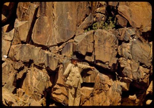 Merl La Voy next to a petroglyph at Scho-Scho, of a giraffe and a small animal with large paws