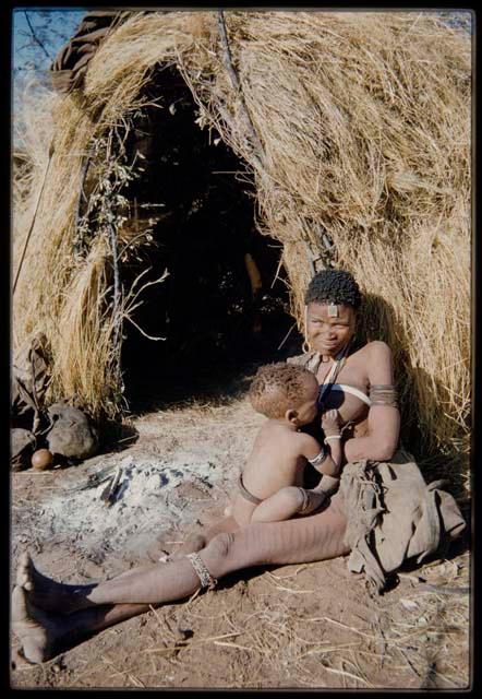 Children, Mothers nursing babies: Woman leaning against a skerm, nursing a child