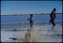 Children, Groups, play: Girls playing "piggyback" by a pan with water in it