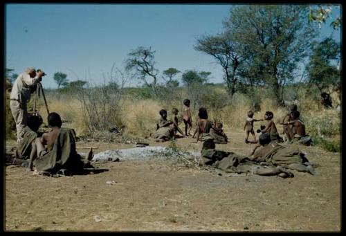 Expedition, Photography: Group of people sitting, including ≠Toma's sister, with Laurence Marshall photographing them