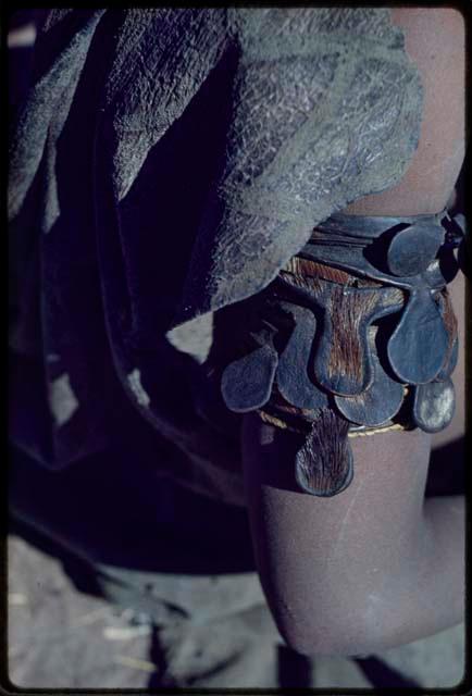 Ornament: Person wearing upper arm bracelets that a man makes for his wife in their first period of marriage made from leather cut from the foreheads of his kills, close-up