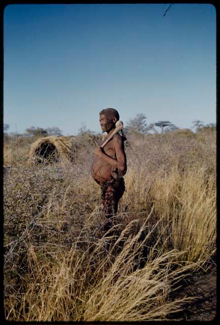 Portraits: "Old Demi" standing and holding an adze over his shoulder