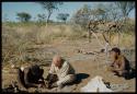 Expedition, Personnel: "Old Gau" fixing Laurence Marshall's shoe, with ≠Toma sitting next to them watching