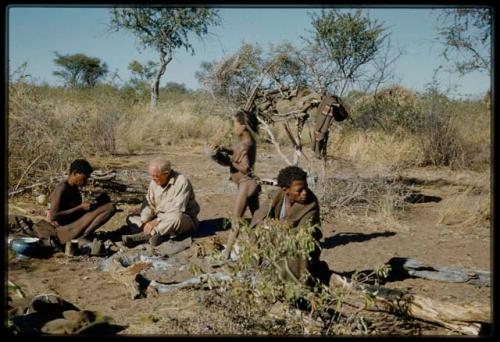 Expedition, Personnel: "Old Gau" fixing Laurence Marshall's shoe, with a child standing next to them and ≠Toma sitting nearby