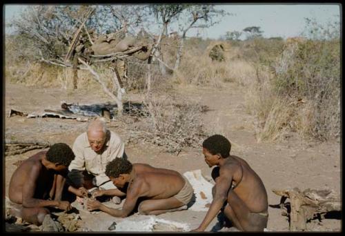 Expedition, Personnel: "Old Gau" and another man fixing Laurence Marshall's shoe, with a man sitting next to them watching