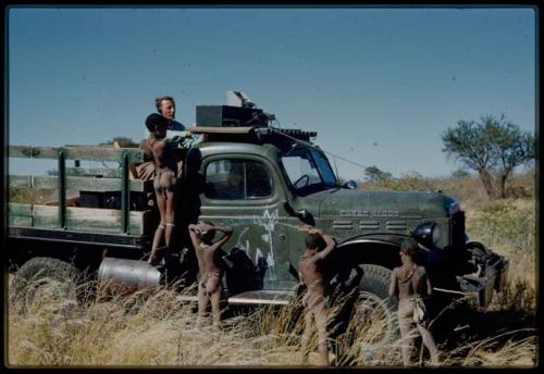 Expedition, Sound Recording: Boys standing on and next to an expedition truck, with Hans Ernst sitting with sound recording equipment in the truck