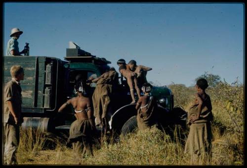 Expedition, Trucks: Group of people climbing on an expedition truck and standing next to it, with John Marshall standing next to them and another expedition member standing in the back of the truck