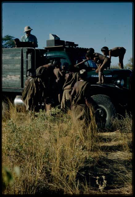 Expedition, Trucks: People climbing on an expedition truck and children looking in the cab, with an expedition member standing in the back of it