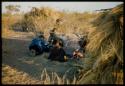 Expedition, Ethnographic work: Two people sitting next to a fire, with Kernel Ledimo and Lorna Marshall bending over a medical case