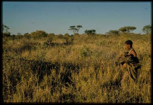 Woman walking through grass in evening light