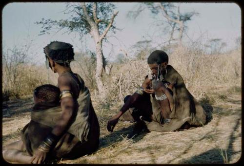 Two women sitting, one holding a baby