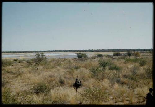 Scenery, Veld: Person carrying things in a net, walking toward a pan with a little water left in it