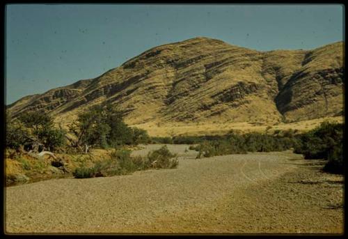 Scenery, Mountains: Rocky soil and brush at the base of a mountain