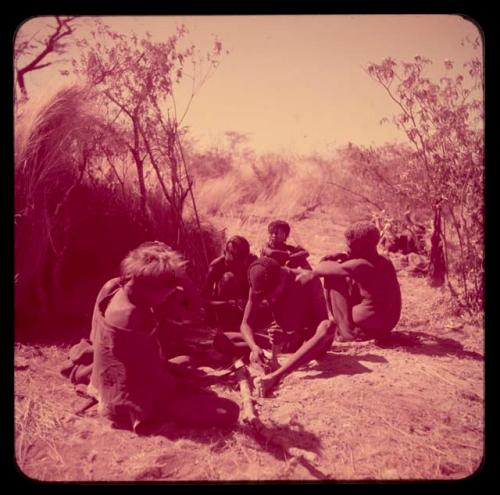 Arrows: "/Gao Music" applying poison to arrows, sitting with a group of people, including !Naishi wearing a hat and "Old Demi"