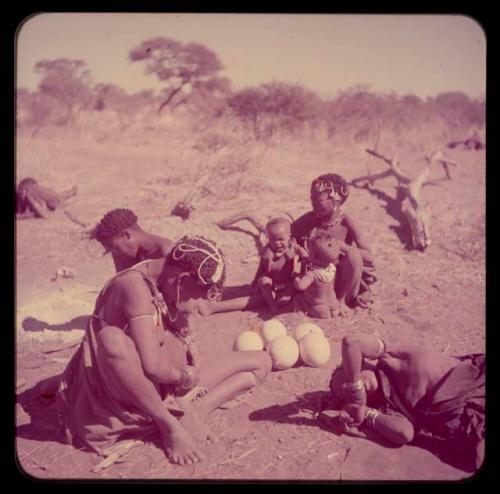 Children, Mother and children: Group of people participating in a haircutting ceremony, with !Ungka holding Sa≠gai and !Ungka Norna, who is crying