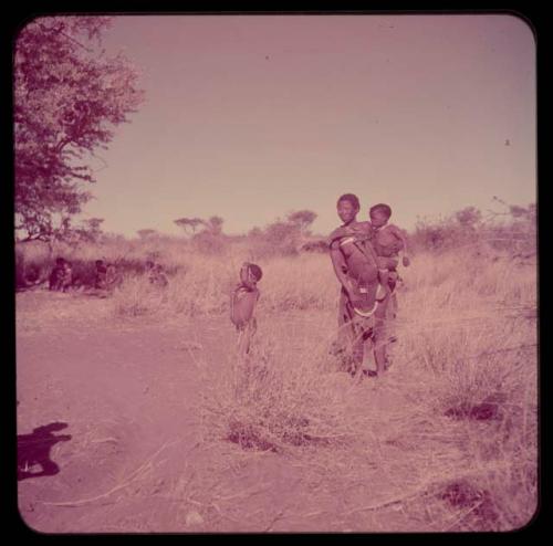 Children, Mother and children: Woman carrying a child, with another child standing next to her