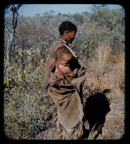 Food Gathering, "Men": Mother carrying her child and a root in her kaross