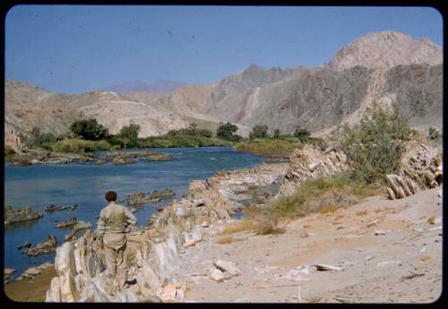 Charles Koch standing next to the Kunene River, with hills in the background