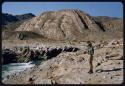 Charles Koch standing near a port on a rocky bank of the Kunene River