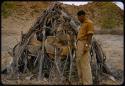 Heinrich Neumann standing beside a skerm with baskets inside it