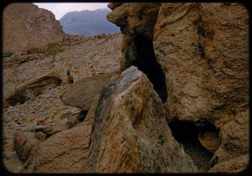 Basket inside a cave, with Heinrich Neumann standing in the background