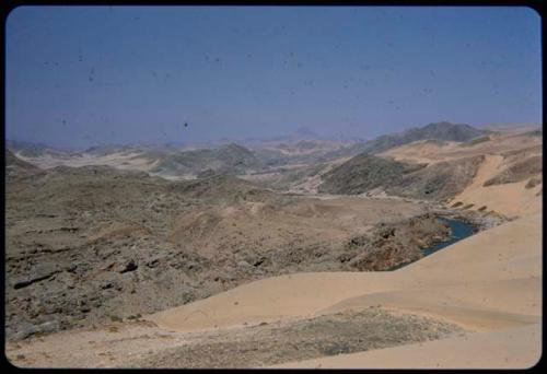 View of the Kunene River from a sand dune, with Angola mountains in the background