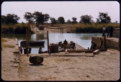 Men loading wood onto a pont on the Kunene River