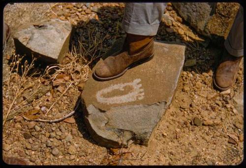 Person's foot next to petroglyph of a foot on a rock on Prinsloo Farm