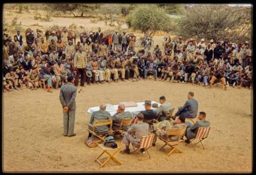 Omajetti indaba, group of men sitting and standing around Laurence Marshall, Colonel Hoogenhout (the South West African administrator), and John Neser sitting at a table