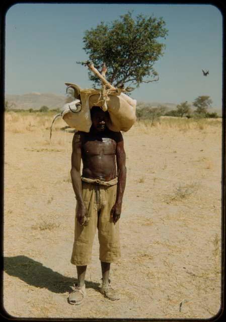 Young man carrying a bundle on his head