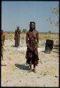 Himba woman standing, with a Herero woman standing behind her