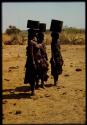 Three women carrying water, standing