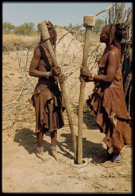 Two women grinding corn