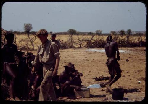 Group of people sitting and standing with expedition members, including John Marshall in foreground