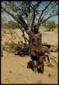 Woman standing with children in front of a tree