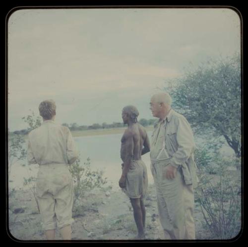 John Marshall, /Ti!kay, and Laurence Marshall standing at the edge of pan