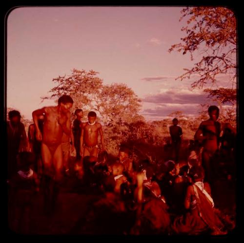 Men performing a curing dance, with women sitting and clapping