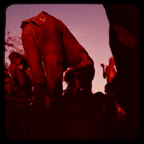 Medicine man bending over, seen from behind