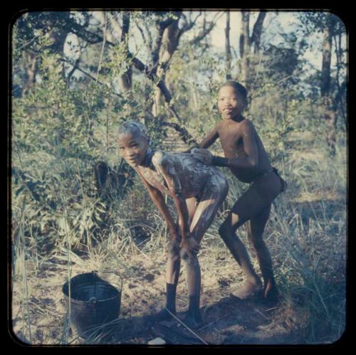 Boy bathing, helped by a friend