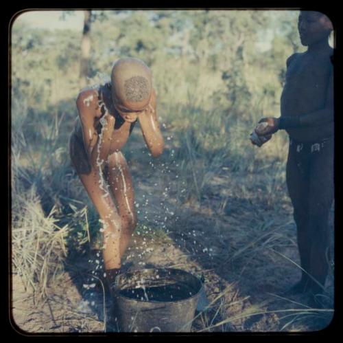 Boy bathing, watching and helped by a friend