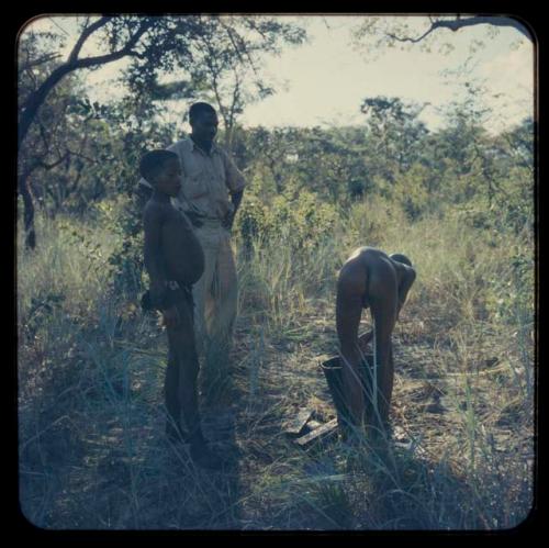 Kernel Ledimo standing with two boys who are in the middle of bathing