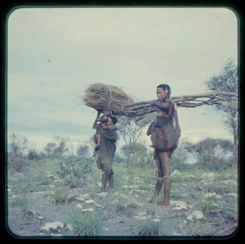 Woman carrying a bundle of grass and a baby and Khuan//a carrying poles and a baby
